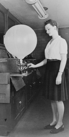 A lady operates a balloon machine.